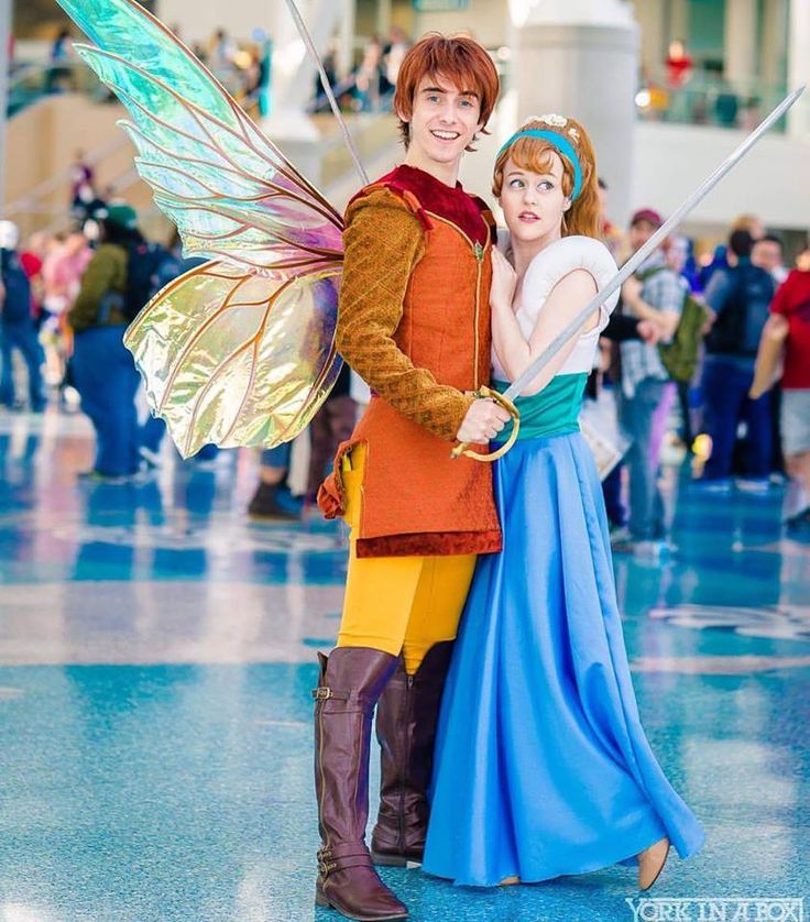 two people dressed up as peter pan and tinkerbell at an indoor convention center