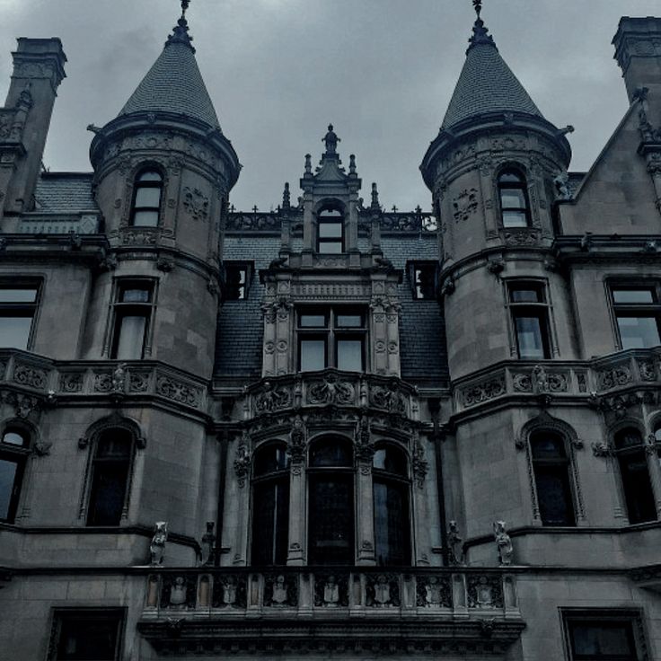 an old castle like building with many windows and towers on top of it's roof