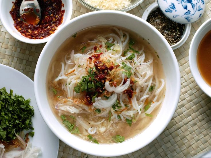 several bowls of food are sitting on a table with chopsticks and spoons