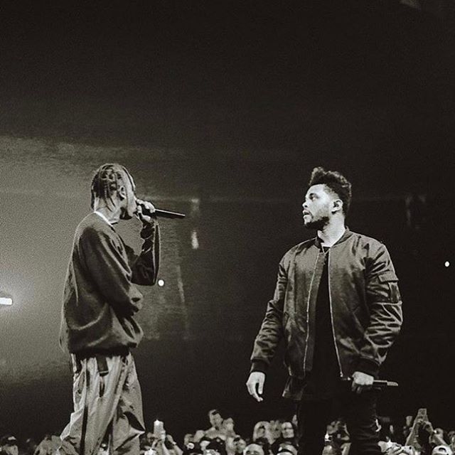 two men standing next to each other on top of a stage with microphones in front of them