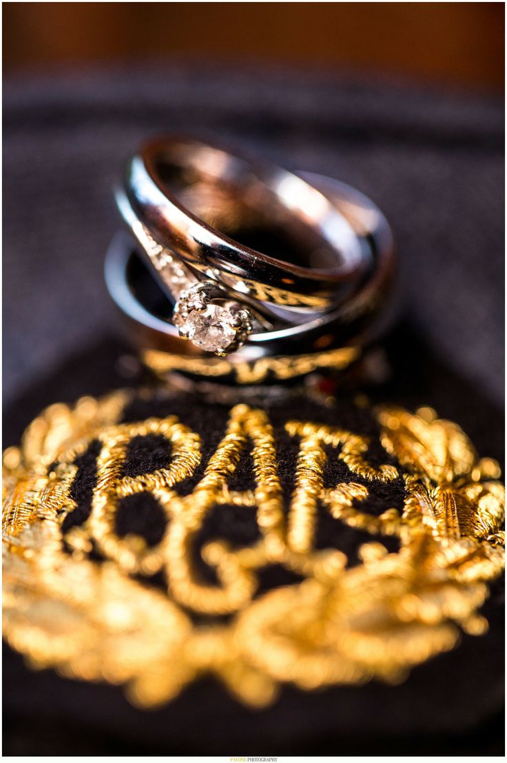 two wedding rings sitting on top of each other with the word love spelled in gold