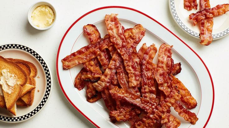 bacon on a plate next to toast and butter