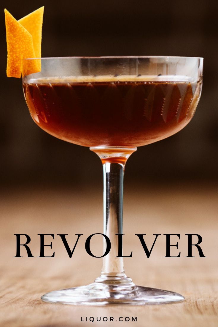 a close up of a drink in a glass on a table with the words revolver above it