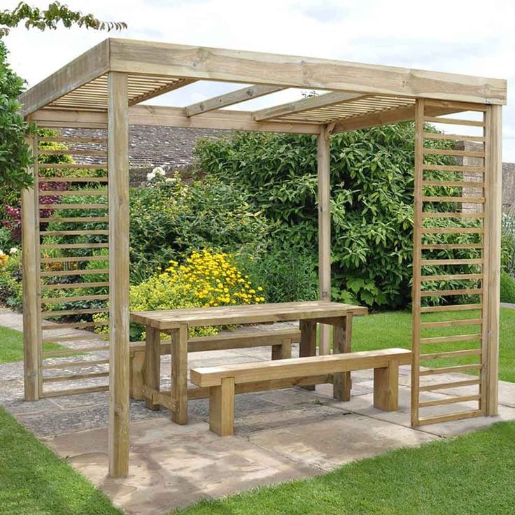 a wooden gazebo with benches and flowers in the background