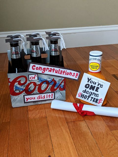 some beer bottles are sitting on the floor with congratulations signs and graduation caps next to them