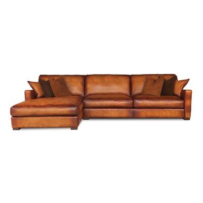 a brown leather sectional couch with pillows on it's back and the seat folded out