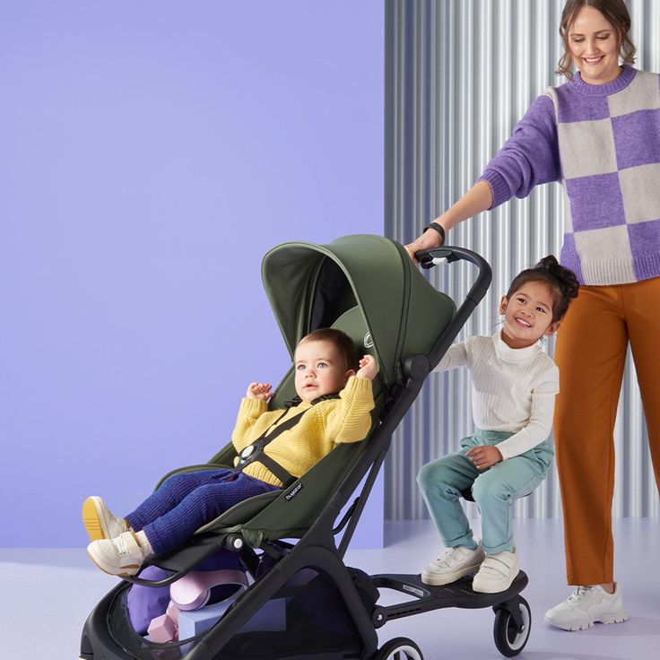 a woman and two children in strollers posing for the camera with their mother holding her hand out