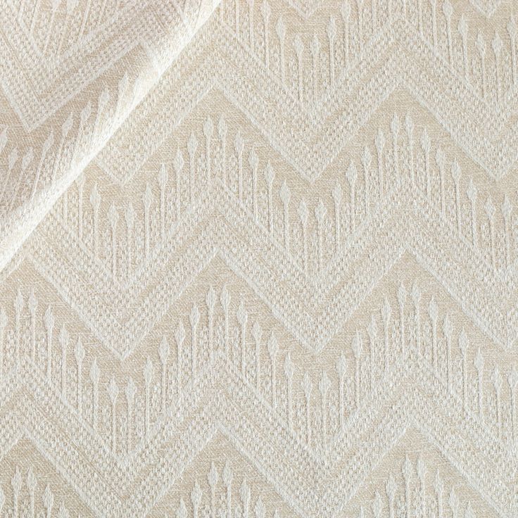 an upholstered white fabric with zigzag pattern on it's side