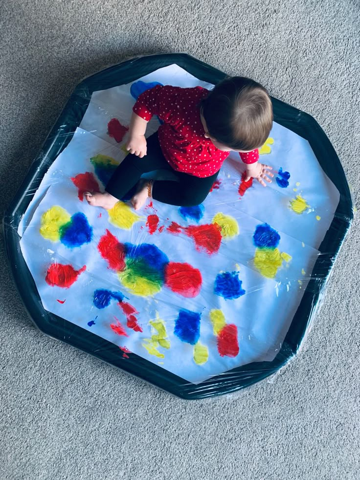 a toddler playing with an inflatable play mat