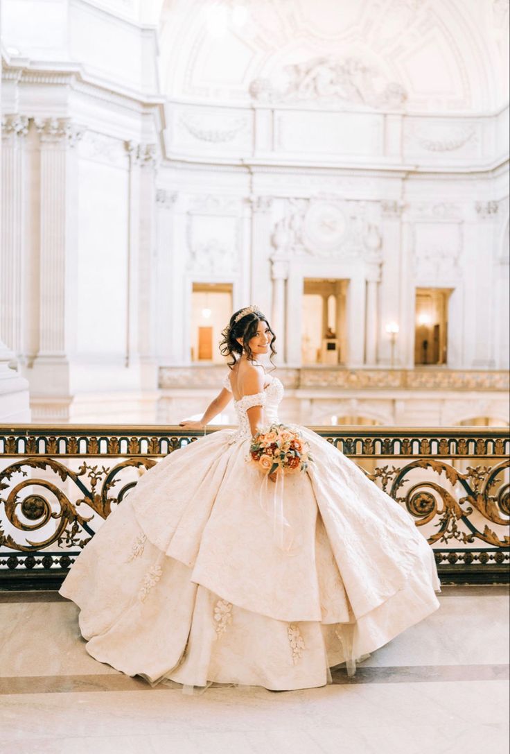 a woman in a wedding dress standing on a balcony