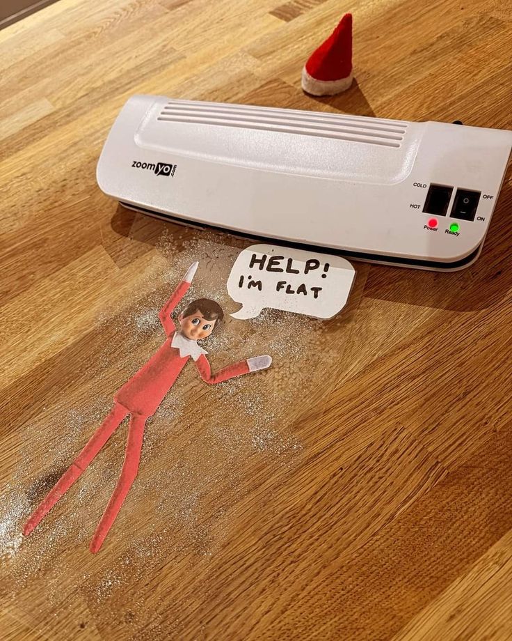 an elf laying on the floor next to a heater with a sign that says help in flat