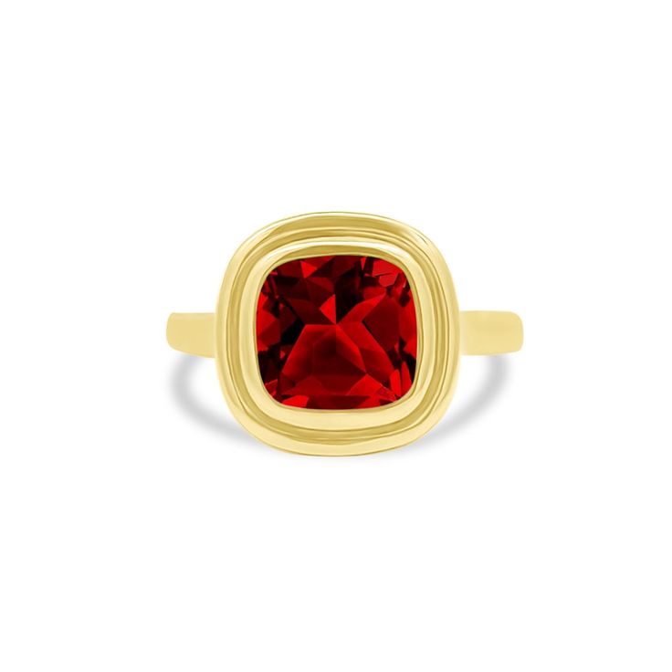 a gold ring with a red stone in the center