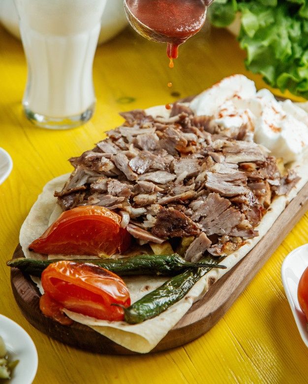 a wooden cutting board topped with meat and veggies