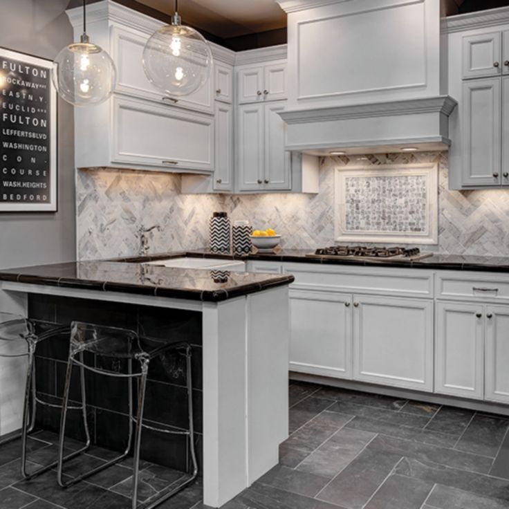 a kitchen with marble counter tops and white cabinets