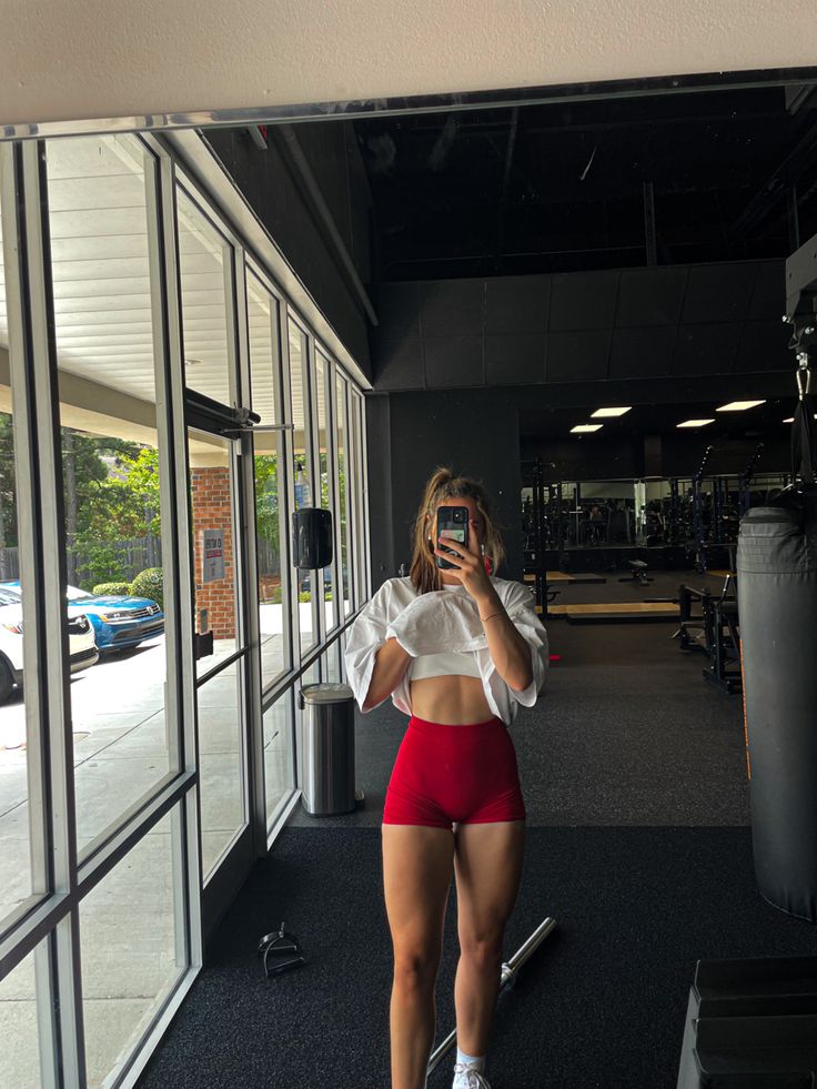 a woman in red shorts taking a selfie