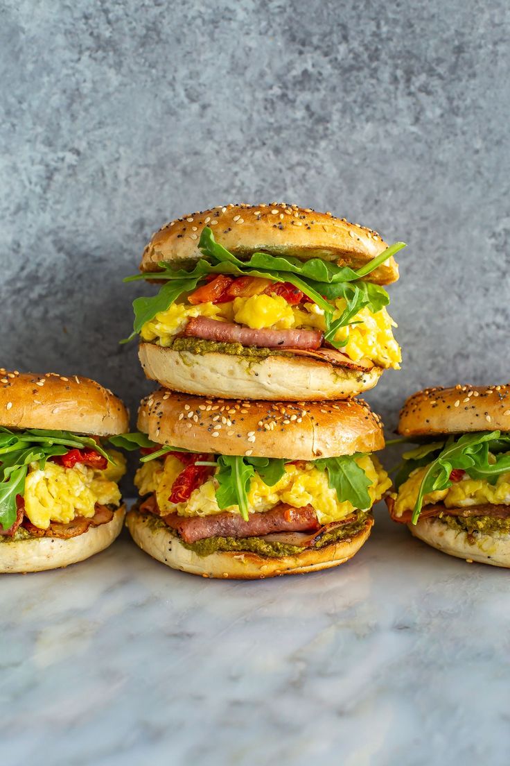 five sandwiches stacked on top of each other with meat and eggs in between the buns