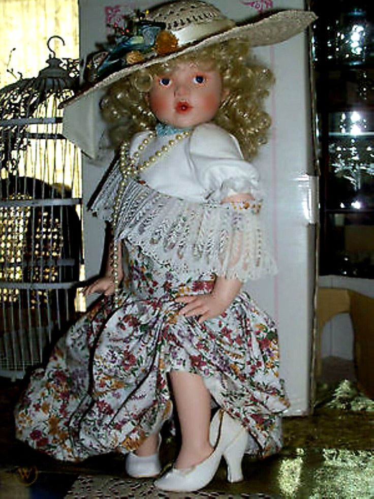 the doll is wearing a dress and hat