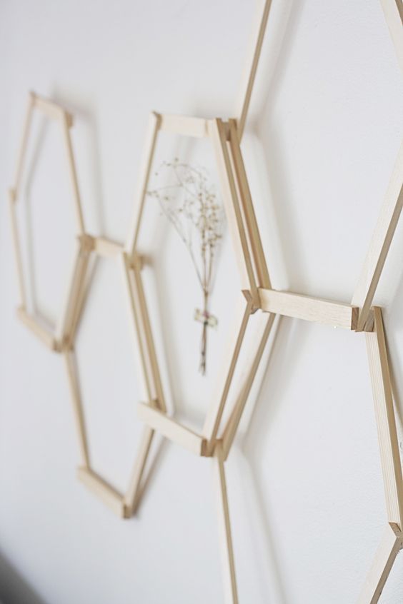 three wooden hexagonals are hanging on the wall with a flower in them