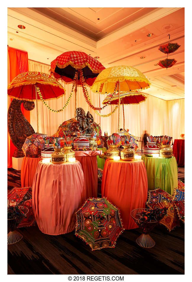 there are many colorful umbrellas hanging from the ceiling in front of tables with lights on them