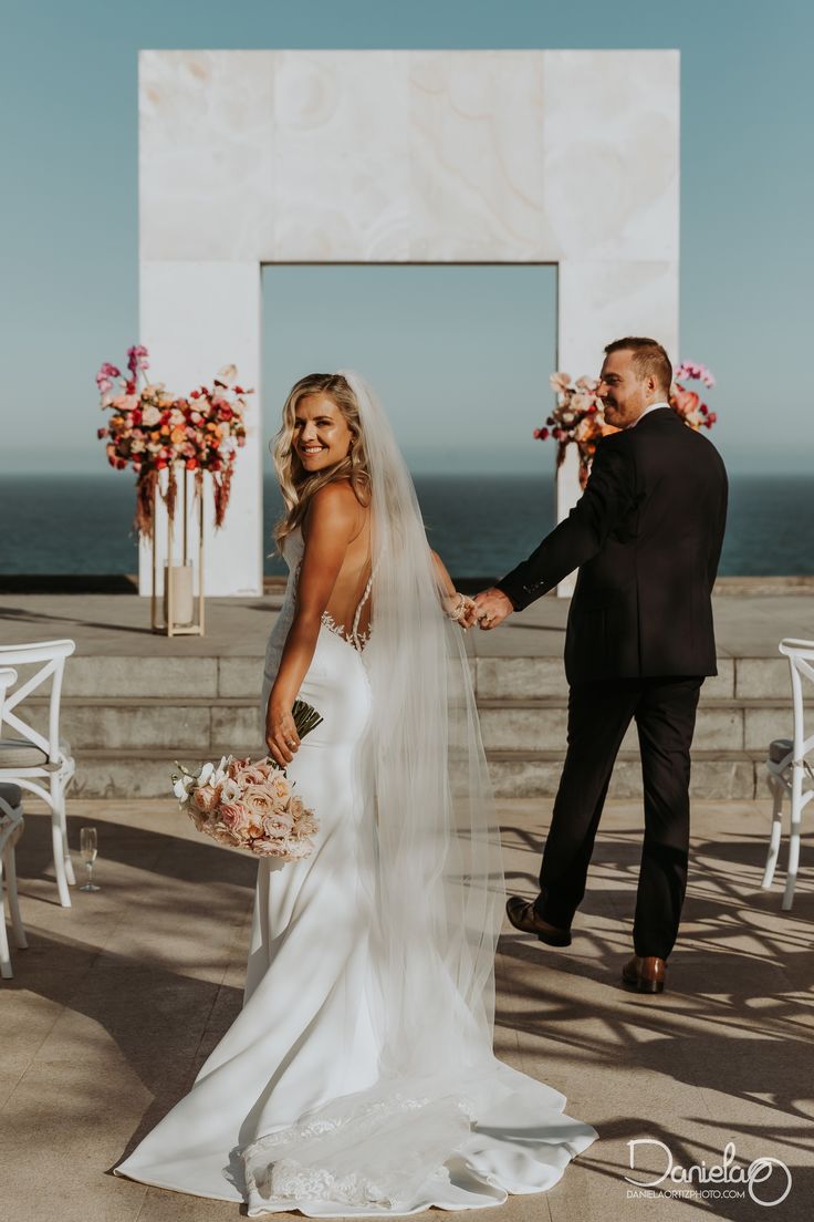 a bride and groom holding hands at their wedding ceremony