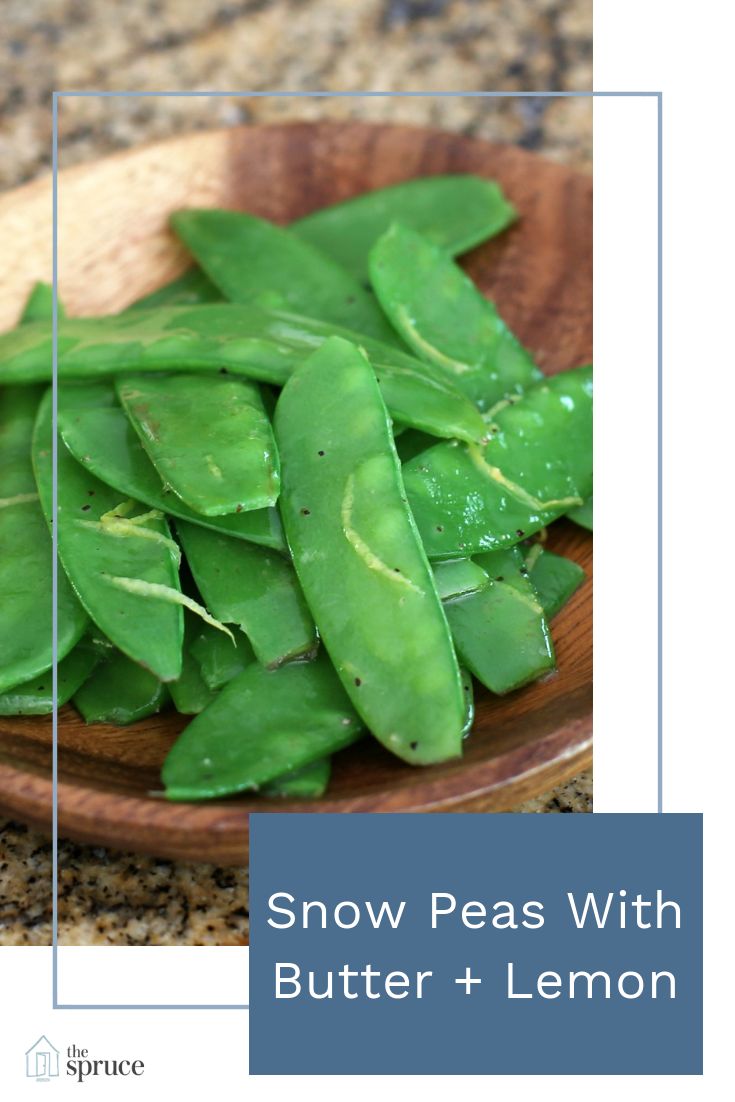 snow peas with butter and lemon in a wooden bowl