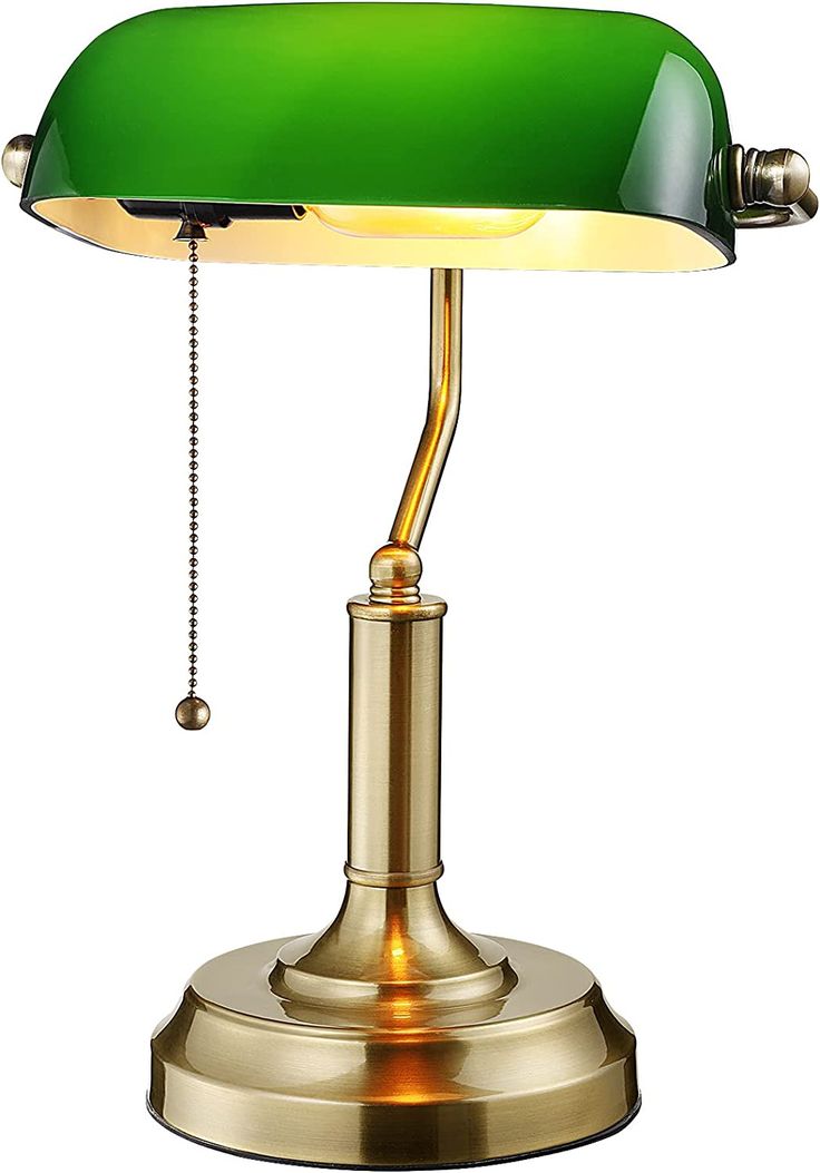 a green and gold desk lamp on a white background