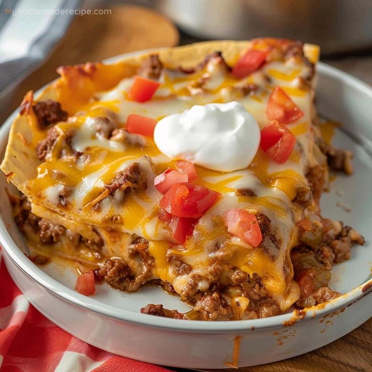 a casserole dish with meat, cheese and tomatoes