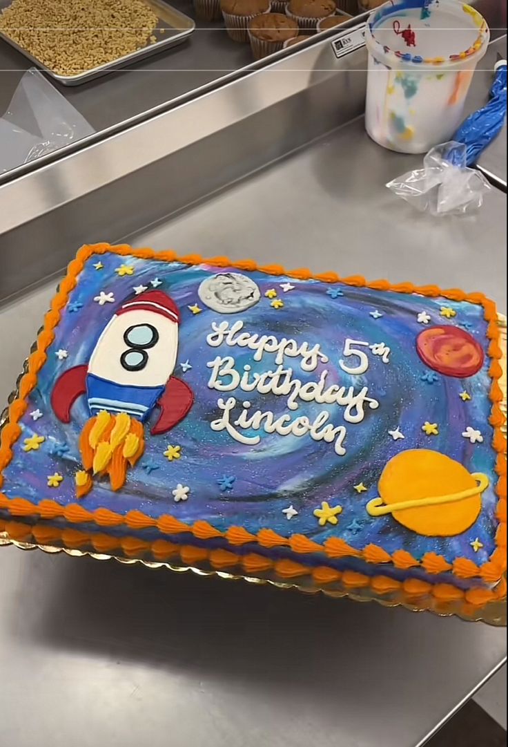 a birthday cake with an image of a rocket ship on it