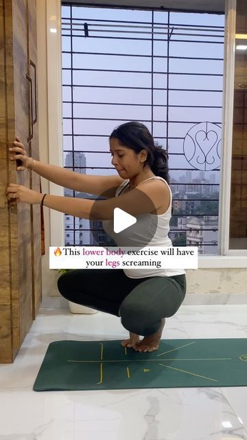 a woman is doing yoga in front of a window