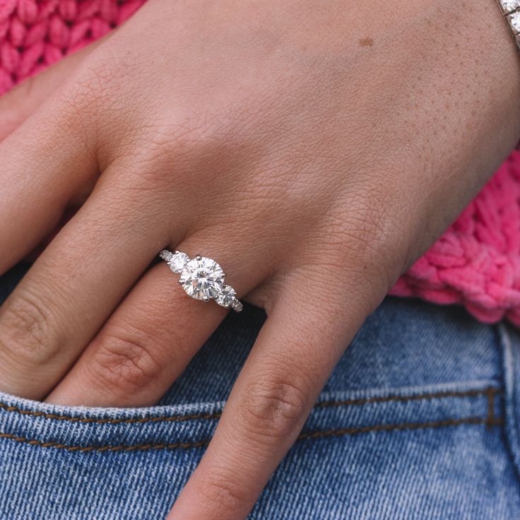 a woman's hand with a diamond ring on her finger