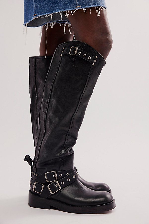 Your favorite buckle-adorned boots from our We The Free collection, now featured in a knee-high silhouette. **Features:** Knee-high length, pull-on style, vegetable-tanned leather, round toe, grommet detailing, adjustable buckle accents, minimal heel, studded detailing throughout **Why We ❤ It:** These bold boots feature hand-stitched detailing and hand-finished leather. Leathers are vegetable tanned and soles are washed with rocks to give a unique look and finish. | We The Free Janey Tall Engin Edgy Knee-high Moto Boots With Buckle Closure, Edgy Knee-high Moto Boots With Buckle, Edgy Knee-high Boots With Buckle Closure, Edgy Over-the-knee Boots For Fall, Edgy Leather Knee-high Boots With Buckle Closure, Punk Style Leather Knee-high Boots With Buckle, Edgy Knee-high Heeled Boots With Buckle Closure, Edgy Knee-high Moto Boots For Fall, Edgy Leather Knee-high Boots With Wide Calf