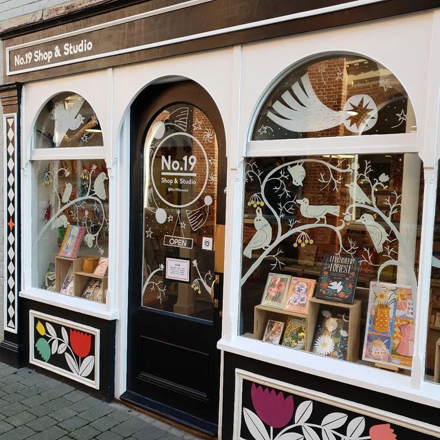 there are many different shops in the street with their windows decorated like flowers and birds