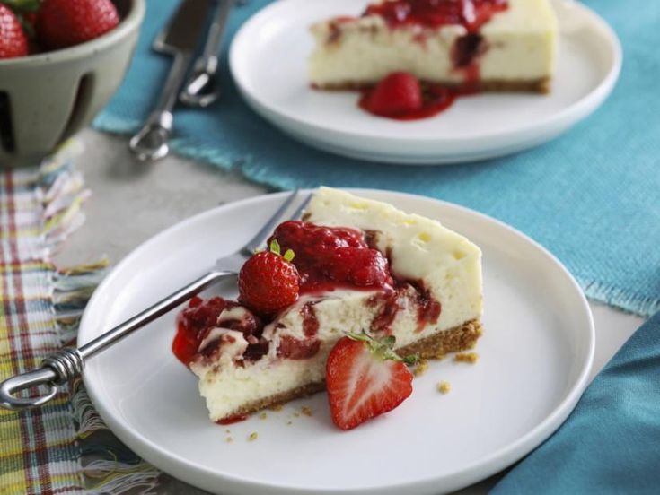 two plates with slices of cheesecake and strawberries