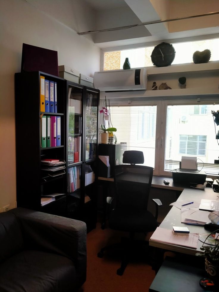 an office area with desk, chair and bookshelf in front of large window