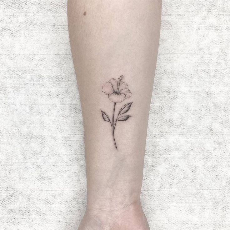 a small flower tattoo on the ankle