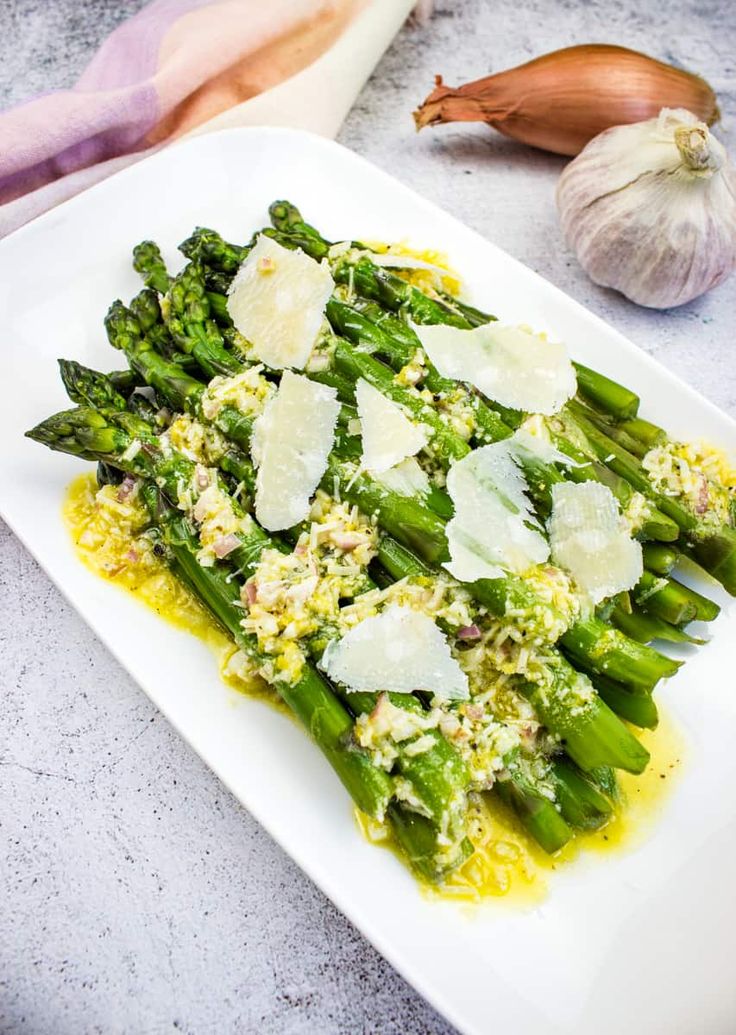 grilled asparagus with lemon and parmesan cheese on a white plate