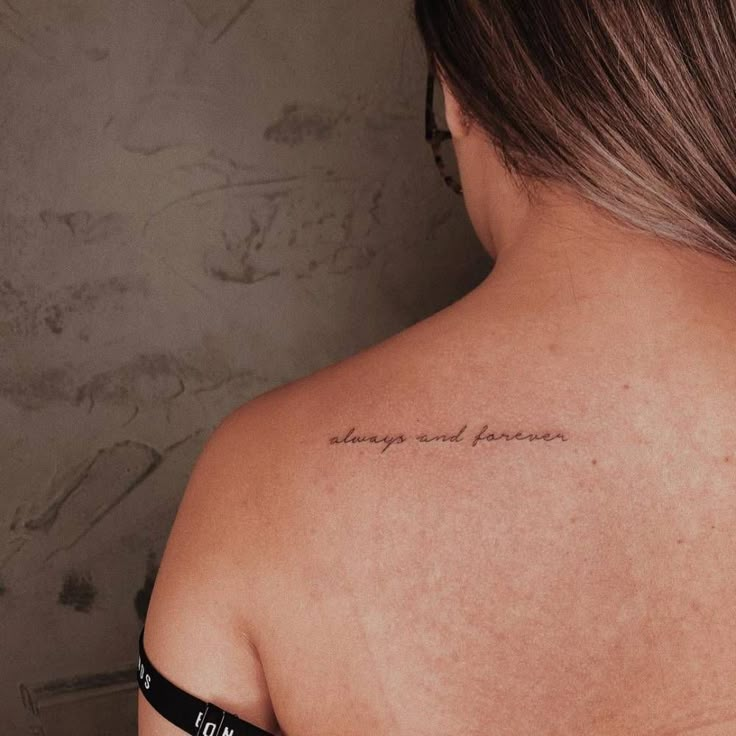 the back of a woman's shoulder with an inscription on it that reads, always and forever