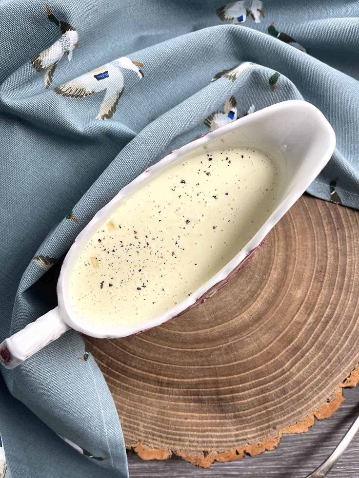 a spoon sitting on top of a piece of wood next to a blue cloth covered tablecloth