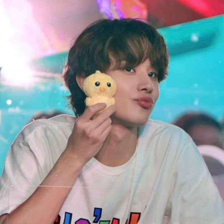 a young man holding a stuffed animal in front of his face