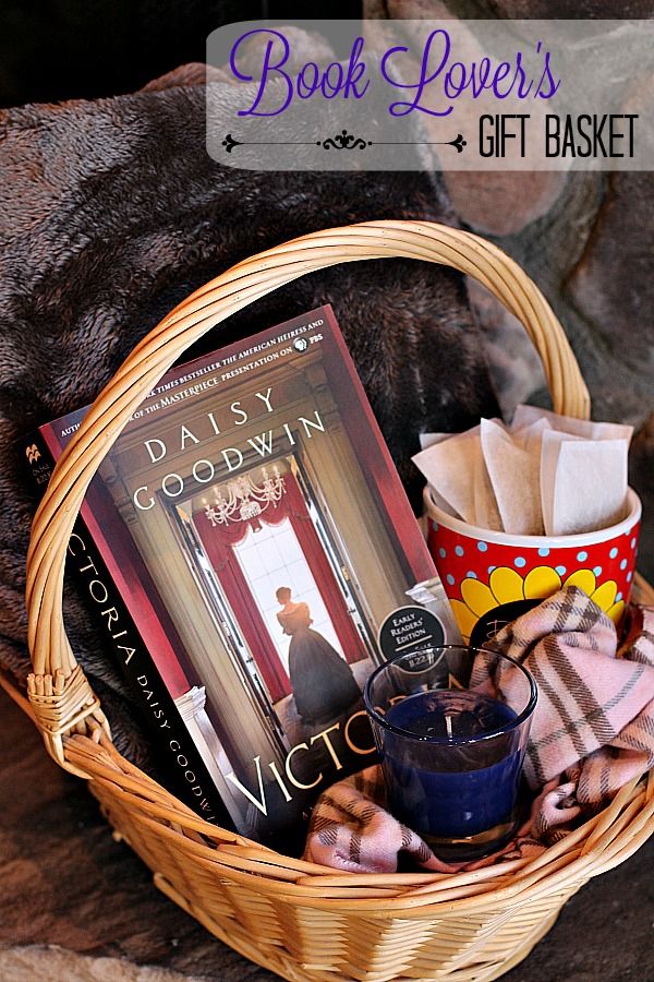 a basket filled with books sitting on top of a wooden table next to a cup