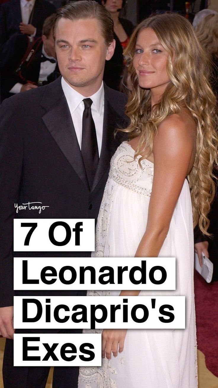 a man and woman standing next to each other in front of an oscars red carpet