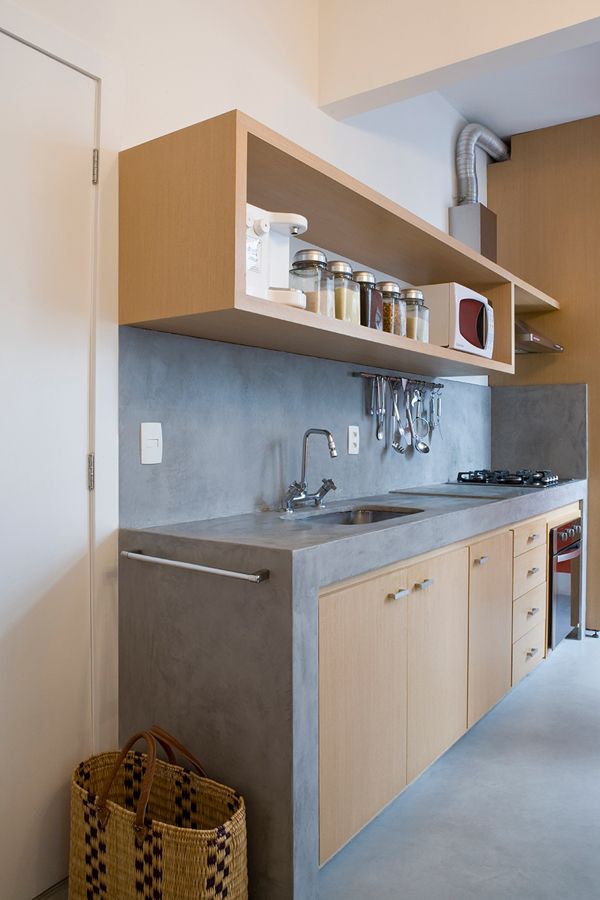 a kitchen area with sink, counter and shelves