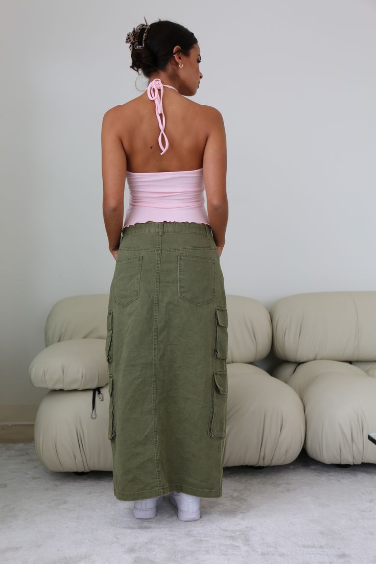 Step up your wardrobe game with the Olivia Cargo Maxi Skirt. Featuring Fall's staple color olive, this cargo maxi is designed to bring utility chic to life. Whether you keep it casual or dress it up, this is the piece you need to get you through the season in style! Make it your go-to and become everyone's style envy! Rigid with Minimal Stretch Center Front Slit Double Cargo Pockets 5 Pocket Maxi Silhouette 100% Cotton Model is 5'6 and wearing a size SMALL Green Cargo Maxi Skirt, Going Out Looks, Green Cargo, Corsets And Bustiers, Top Streetwear, Cargo Skirt, Denim Details, Dress Romper, Trending Now