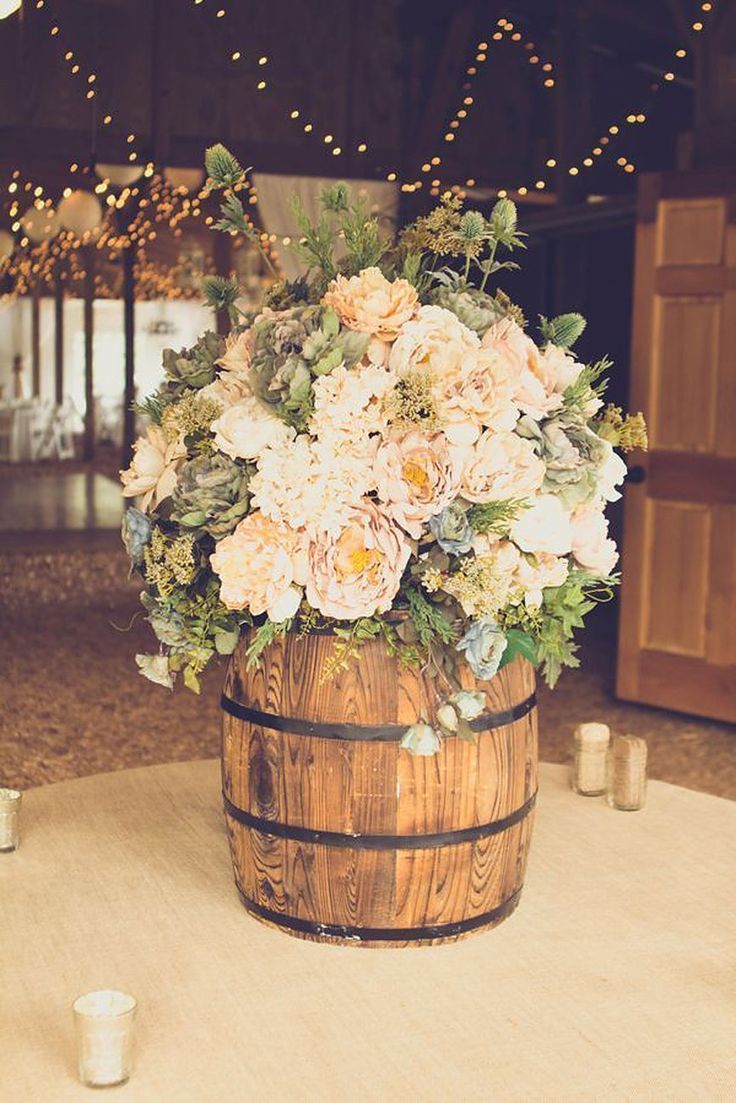 a wooden barrel filled with flowers on top of a table