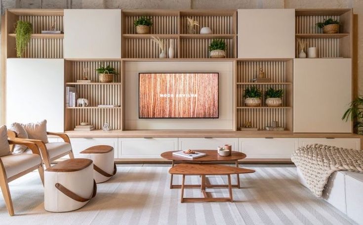 a living room filled with furniture and a flat screen tv mounted on a wall above it