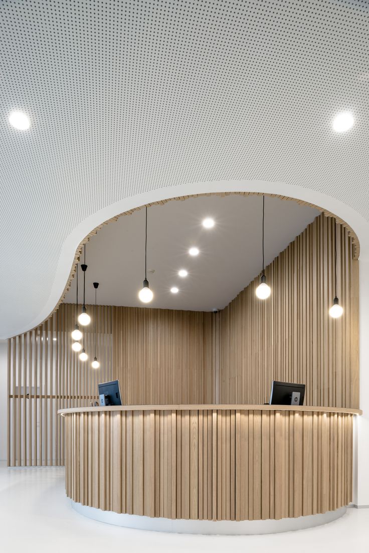 the interior of a modern office building with wood paneling and round lighting fixtures on the ceiling