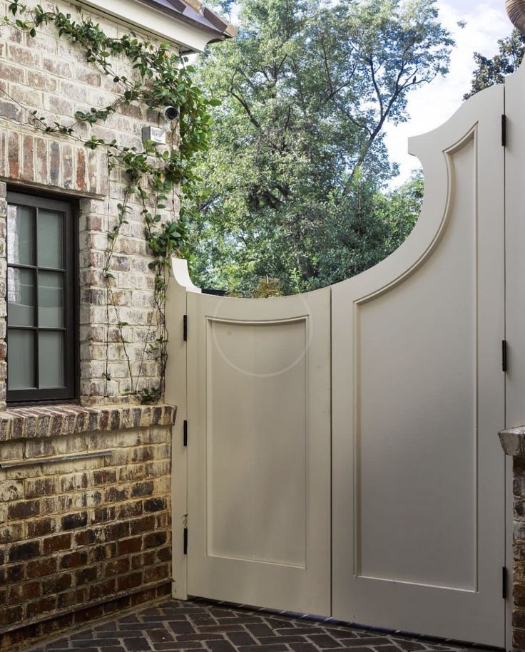 an open white door in front of a brick building