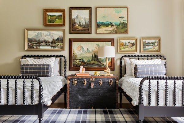 a bedroom with two twin beds and pictures on the wall above them, along with a suitcase