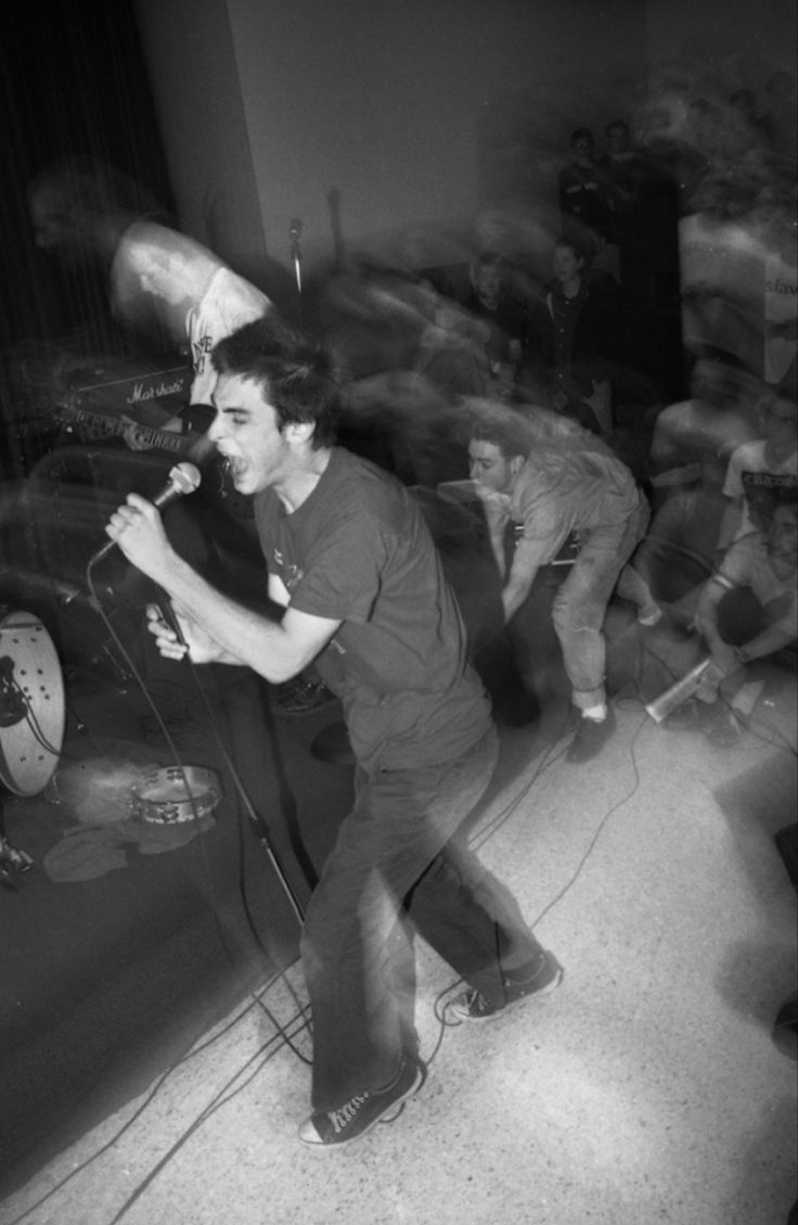 a man standing on top of a floor holding a microphone in front of other people