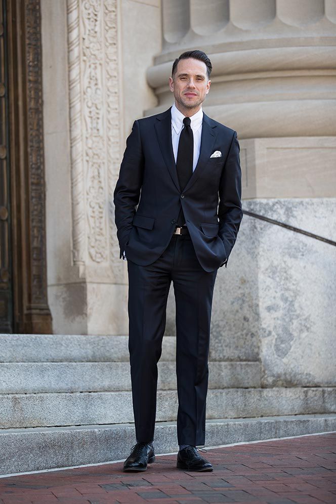 a man in a suit and tie standing on steps